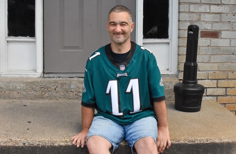 Michael sits on front porch, celebrating 4 years at KenCrest